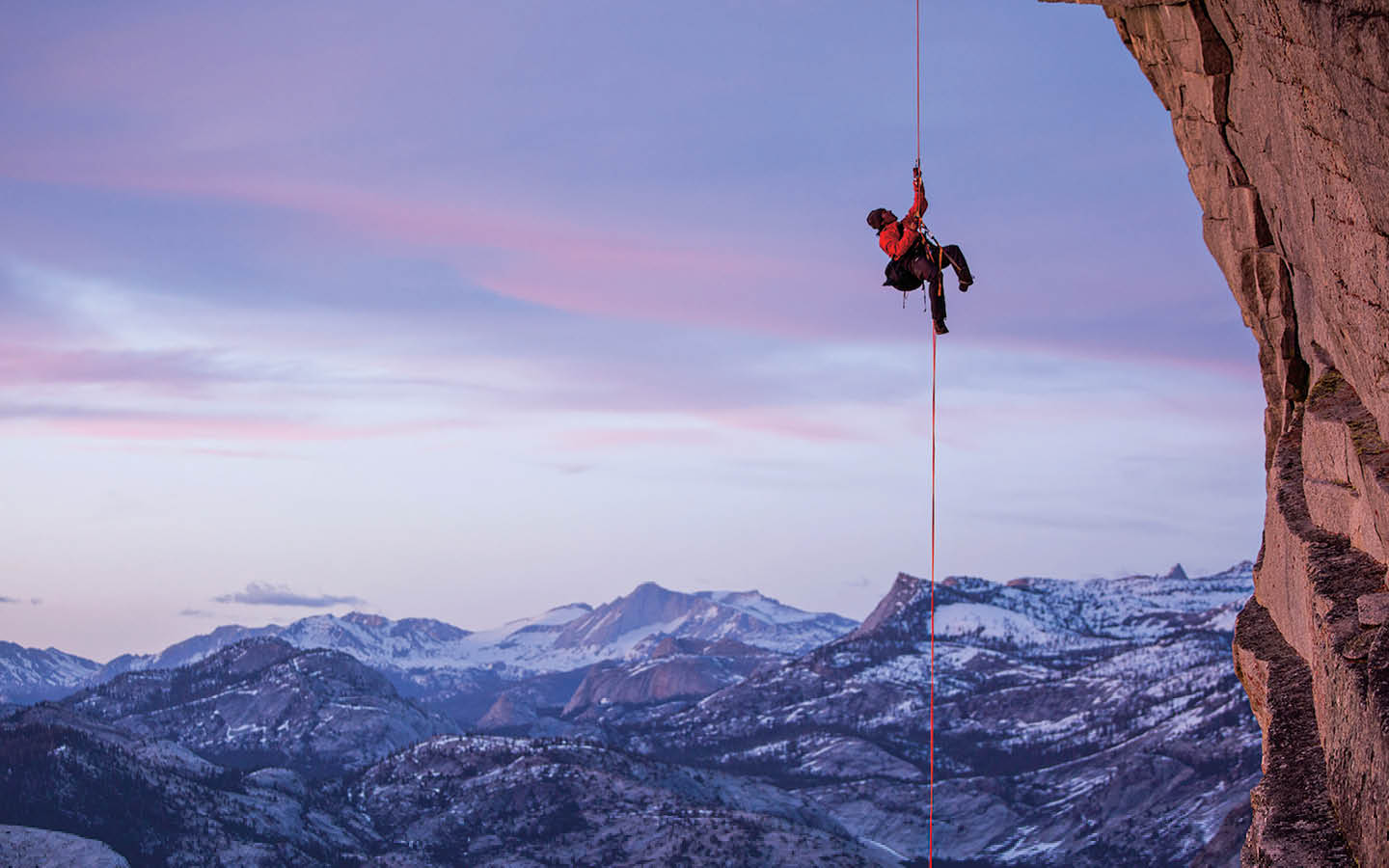 Image of a rock climber high up a mountain