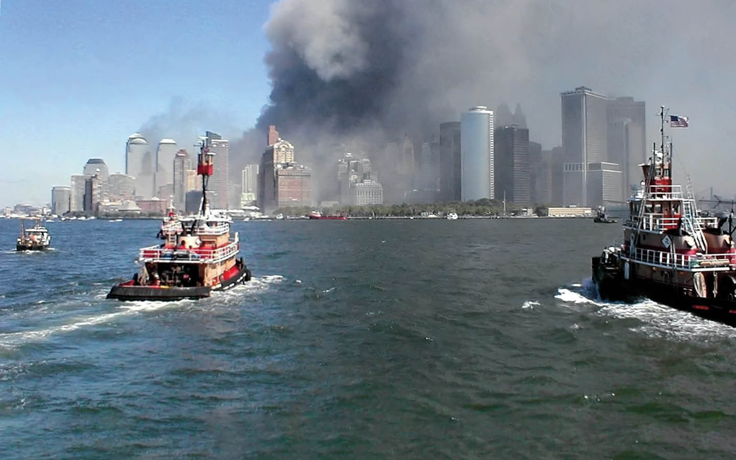 Photo of rescue boats traveling to Manhattan to smoking buildings